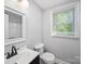 Well-lit bathroom with modern black fixtures, sleek vanity, and a window for natural light at 1142 Mona Dr, Charlotte, NC 28206