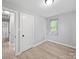 This bedroom features neutral walls, base trim, and wood-look floors, plus a window at 1142 Mona Dr, Charlotte, NC 28206