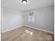 This bedroom features neutral walls, base trim, and wood-look floors, plus a window at 1142 Mona Dr, Charlotte, NC 28206