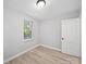 This bedroom features neutral walls, base trim, and wood-look floors, plus a window at 1142 Mona Dr, Charlotte, NC 28206