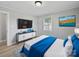 This decorated bedroom has wood-look floors, neutral walls, and a big TV at 1142 Mona Dr, Charlotte, NC 28206