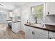 Modern kitchen featuring new cabinets, new floors, and view to a backyard door at 1142 Mona Dr, Charlotte, NC 28206