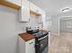 Modern kitchen featuring new cabinets, new floors, and view to a bedroom at 1142 Mona Dr, Charlotte, NC 28206