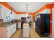 Open kitchen featuring white cabinets, black appliances, a portable island, and easy access to the dining area at 116 Pelham Ln, Fort Mill, SC 29715