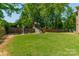 Spacious backyard featuring a wooden playset with swings and a slide, perfect for Gathering fun at 12525 Hashanli Pl, Matthews, NC 28105