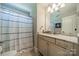 Clean bathroom with vanity and granite countertop with striped curtain and a framed octopus art piece at 12525 Hashanli Pl, Matthews, NC 28105