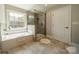 This spacious main bathroom features a separate shower, tub, and great natural light at 12525 Hashanli Pl, Matthews, NC 28105