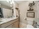 Bright bathroom with a vanity, granite countertop, and a decorative floating shelves and towels at 12525 Hashanli Pl, Matthews, NC 28105