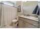 Bright bathroom with a granite countertop vanity, decorative mirror, and tiled shower with patterned curtain at 12525 Hashanli Pl, Matthews, NC 28105