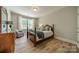 Cozy bedroom with hardwood floors, natural light, and a decorative green blanket on the bed at 12525 Hashanli Pl, Matthews, NC 28105
