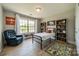 Well-lit bedroom featuring hardwood floors, a reading chair, and decorative bookshelves at 12525 Hashanli Pl, Matthews, NC 28105