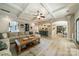 Open-concept living room with hardwood floors, coffered ceiling, and stylish furnishings at 12525 Hashanli Pl, Matthews, NC 28105