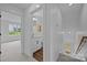 Hallway view of a bright bathroom with white vanity, shower, and wood-look floors at 130B Springway Dr, Kannapolis, NC 28081