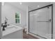 Modern bathroom with a glass shower, white tile, black hardware, and a vanity with quartz countertop at 130B Springway Dr, Kannapolis, NC 28081