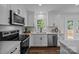 Modern kitchen with white cabinets, stainless steel appliances, quartz countertops, and a stylish backsplash at 130B Springway Dr, Kannapolis, NC 28081