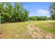 A sprawling front yard with a partly exposed dirt path, surrounded by mature trees at 1317 Requa Rd, Cherryville, NC 28021