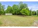 Quaint one-story home with a green lawn and ample privacy provided by mature trees at 1317 Requa Rd, Cherryville, NC 28021