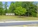 One-story home with a green lawn, complemented by mature trees for added privacy and shade at 1317 Requa Rd, Cherryville, NC 28021