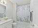 Bright bathroom with a white vanity, marble floors, and a tub with a floral shower curtain at 1409 Bloomsberry Ln, Waxhaw, NC 28173