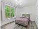 This bedroom features a large window, hardwood floors, and a tufted headboard at 1409 Bloomsberry Ln, Waxhaw, NC 28173