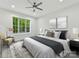 Bright bedroom showcasing a ceiling fan, modern accents, a large window, and comfortable furnishings at 1409 Bloomsberry Ln, Waxhaw, NC 28173