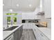 Bright kitchen with white and gray cabinets, stainless steel appliances, and a view to the backyard at 1409 Bloomsberry Ln, Waxhaw, NC 28173