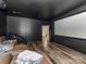 Home theater with dark walls, wood floors, a large screen, and leather seating at 1409 Bloomsberry Ln, Waxhaw, NC 28173