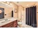 Neutral bathroom with a cherry vanity, marble countertop, shower and tub combination with a black curtain at 14131 Lea Point Ct, Huntersville, NC 28078