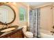 Cozy bathroom with a wood vanity, a round mirror, and a shower with a tub at 14131 Lea Point Ct, Huntersville, NC 28078