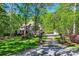 Charming home with stone and brick exterior, manicured lawn, trees and long driveway at 14131 Lea Point Ct, Huntersville, NC 28078