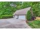 Spacious detached garage with a basketball hoop, large driveway, and mature landscaping at 14131 Lea Point Ct, Huntersville, NC 28078