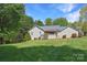 Well-maintained backyard with mature trees and the rear of the home, including a screened-in porch at 1537 Haupt Strasse None, Conover, NC 28613