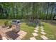 Landscaped backyard with an outdoor dining area, grill, and lush green lawn, offering a serene outdoor retreat at 1543 Ab Moore Jr Dr, Indian Trail, NC 28079