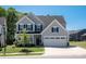 Beautiful two-story home featuring gray siding, black shutters and a two car garage surrounded by a lush green lawn at 1543 Ab Moore Jr Dr, Indian Trail, NC 28079