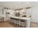Spacious kitchen with an island that has seating, white cabinets, stainless steel appliances, and modern lighting at 1543 Ab Moore Jr Dr, Indian Trail, NC 28079