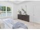 Bright bedroom featuring carpeted floors, tray ceiling, a large window, and a dark dresser at 1615 Martin Ave, Gastonia, NC 28052