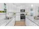 Modern kitchen with granite countertops, stainless steel appliances, white cabinetry, and wood floors at 1615 Martin Ave, Gastonia, NC 28052
