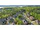 A picturesque view of a neighborhood surrounded by lush greenery and a serene lake in the distance at 16532 Flintrock Falls Ln, Charlotte, NC 28278