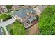 Aerial shot features a brick home with screened porch, patio area, and landscaping in a lush, green setting at 16532 Flintrock Falls Ln, Charlotte, NC 28278