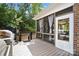Spacious covered back deck features a screened-in porch, ideal for entertaining while overlooking green trees at 16532 Flintrock Falls Ln, Charlotte, NC 28278