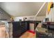 This is a bar area with stone facade, dark cabinetry, a mini fridge, and granite counter tops at 16532 Flintrock Falls Ln, Charlotte, NC 28278