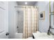 Bright bathroom featuring a tub and shower combination with stylish, geometric curtains at 16532 Flintrock Falls Ln, Charlotte, NC 28278