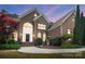 Brick home featuring an arched entryway, manicured landscaping and inviting front steps at 16532 Flintrock Falls Ln, Charlotte, NC 28278