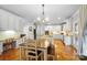 Bright open kitchen featuring white cabinetry, stainless steel appliances, island and light hardwood floors at 16532 Flintrock Falls Ln, Charlotte, NC 28278