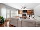 Sunlit living room with a fireplace, wood accent wall, ceiling fan, and large windows with plantation shutters at 16532 Flintrock Falls Ln, Charlotte, NC 28278