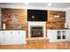 A cozy living room with a wood-paneled accent wall, fireplace, and built-in cabinetry at 16532 Flintrock Falls Ln, Charlotte, NC 28278