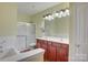 Bathroom features double sinks, large mirrors, and a combined tub and shower at 16746 Amberside E Rd, Cornelius, NC 28031
