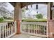 Cozy, covered patio with brick columns, white railing, and views of the community lawn at 16746 Amberside E Rd, Cornelius, NC 28031