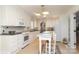 Well-lit kitchen featuring white cabinets, appliances, tile floor, and an eat-in breakfast table at 17333 Saranita Ln, Charlotte, NC 28278