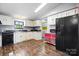Kitchen boasts white cabinets, dark countertops, black appliances, and a convenient laundry area at 2003 Cape Hickory Cutoff Rd, Hickory, NC 28601